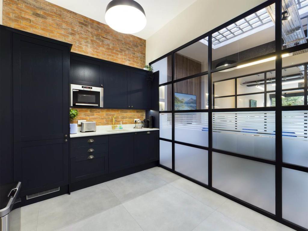 Premium staff kitchen with exposed brickwork and glazed partition